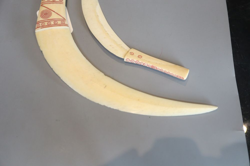 Two tribal carved warthog or boars tusk daggers, first half 20th century, picked out in red pigment